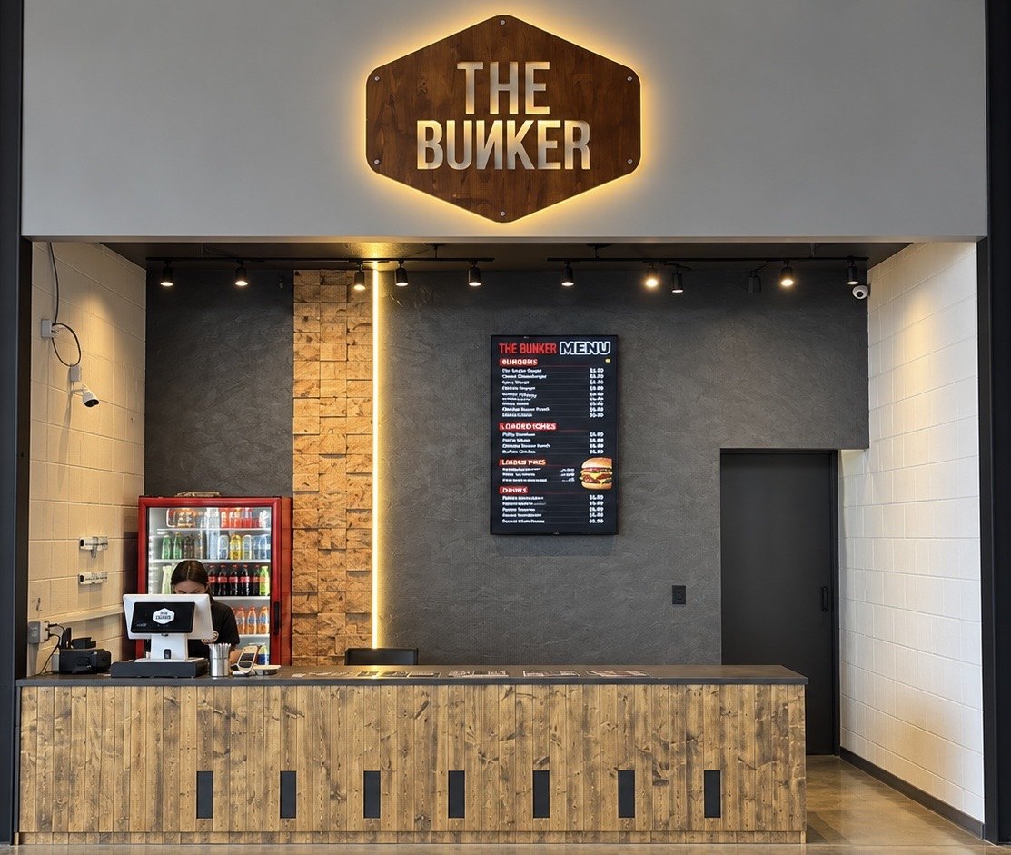 Mostrador de The Bunker con letrero iluminado y menú de hamburguesas